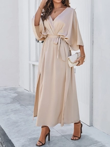 Detail of elegant beige satin dress with deep V-neckline and stylish batwing sleeves