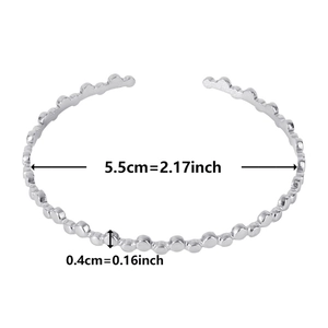 Detail view of silver C-shaped steel bracelet showing 5.5cm diameter and bubble texture