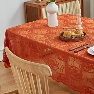 Close-up of vintage orange lace tablecloth with intricate floral openwork pattern