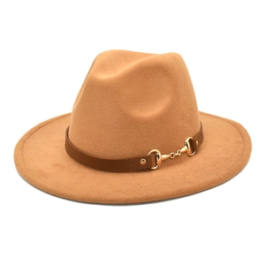 Close-up of camel wool fedora hat featuring a brown leather band and gold horsebit buckle