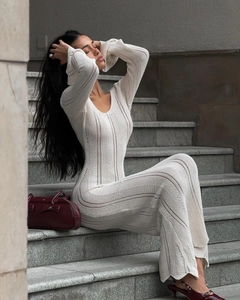 Detailed knit texture of an off-white V-neck dress with hollow-out stripe patterns