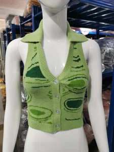 Vista dettagliata del gilet in maglia verde con motivi a contrasto e bottoni frontali
