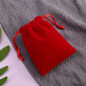Red velvet drawstring jewelry pouch for small gifts shown in a high-quality top view