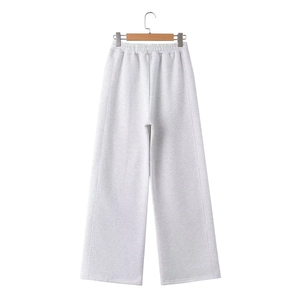 Detail of light grey wide-leg sweatpants featuring an elastic waistband and soft knit fabric