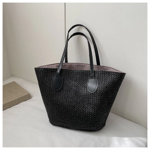 Close-up of black straw woven tote bag texture with leather handle and inner lining