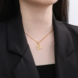 Close-up of model wearing a gold 18K plated heart pendant necklace with I ❤️ MOM engraving