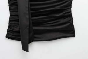 Close-up of black satin fabric with pleated texture and silk-like glossy finish