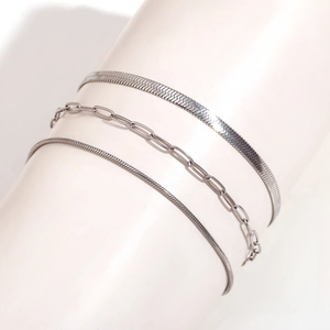 Detailed view of three-piece silver-tone layered anklets with snake and paperclip chains