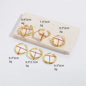 Set of 6 gold cross rings with cubic zirconia and colorful gems on beige stone