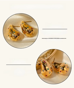 Close-up of 18K gold plated teardrop earrings with colorful zircon inlay on satin