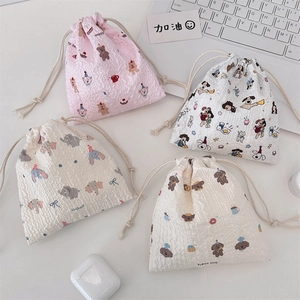 Detail of four seersucker drawstring bags with cute cartoon bear and elephant prints