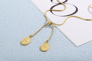Detail of adjustable gold snake chain with embossed Virgin Mary oval pendants