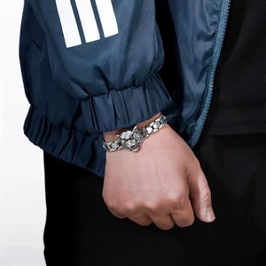 Detailed view of silver tiger head bracelet with hexagonal links on male wrist