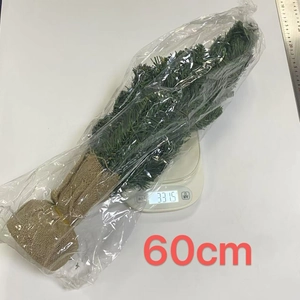 Detailed view of 60cm artificial Christmas tree with burlap base being weighed at 331.5g