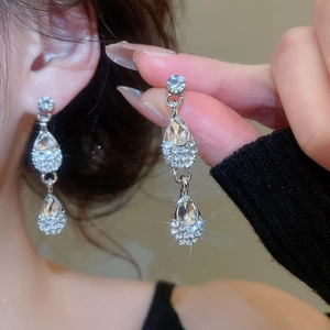 Close-up of elegant silver drop earrings with shimmering crystals and intricate design
