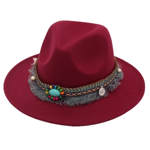 Detail of burgundy felt fedora featuring ethnic beads, turquoise stone and vintage coin