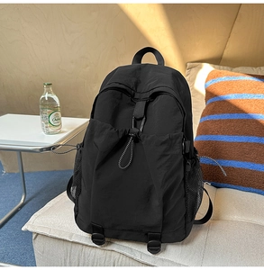 Details eines minimalistischen schwarzen Rucksacks mit Kordelzug und Metallschnallen