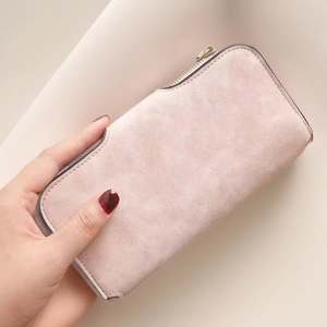 Detailed texture of dusty rose matte leather long wallet with smooth metal zipper closure