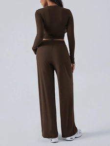 Detail view of the back design on women's brown long sleeve crop top and flared pants set