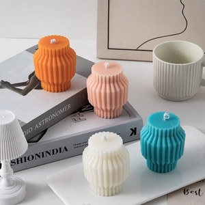 Detail of four colorful striped geometric pillar candles on decorative book props