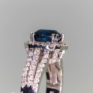 Macro side view of silver ring with large blue zircon and triple-row micro-pave setting