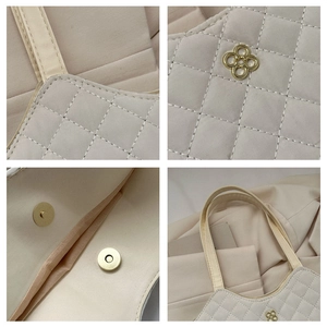 Vue détaillée du sac cabas matelassé beige avec logo doré, fermoir aimanté et poignées