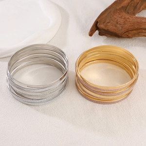 Detailed macro view of multi-layered gold and silver bangles with glitter and smooth finish