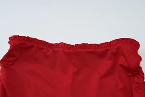 Detailed close-up of red ruched fabric with delicate frill edges and silky texture