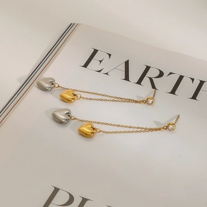 Detail of stainless steel heart earrings with long fringe chains and rhinestone studs