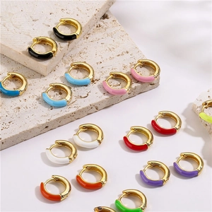 Detailed view of colorful enamel huggie earrings with polished gold-tone metal base
