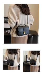 Close-up of black lychee grain leather bag with elegant square gold metal buckle