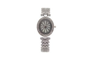 Detailed close-up of oval silver watch featuring flower dial and sparkling crystal inlay