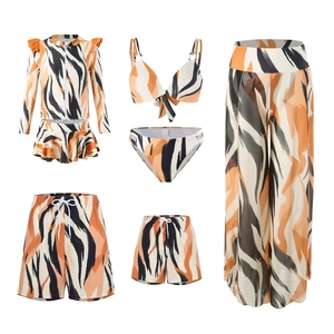 Detailed group shot of family swimwear set featuring vibrant orange tiger print patterns