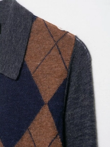 Detail of knit polo shirt collar and diamond argyle pattern in navy and brown