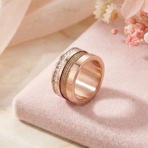 Detail of rose gold titanium ring with Roman numerals and steel wire cable texture