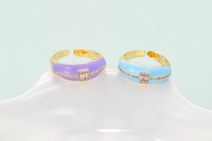 Detail of enamel open rings with crystal inlay in purple and light blue gold plating