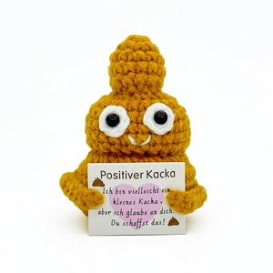 Detail of crochet poop plush with German positive message card on white background