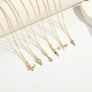 Close-up of six gold pendant necklaces featuring butterfly, leaf, dragonfly and key designs