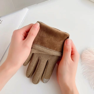 Detailed close-up of brown winter gloves featuring touch screen fingertips and faux fur cuffs