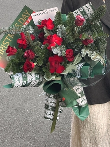 Detail showing red rose bouquet in dark green snowflake paper and Christmas card