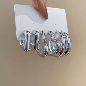 Vue détaillée de boucles d'oreilles argentées géométriques avec cercles et formes de cœur