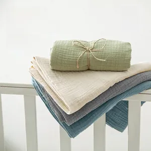 Dettaglio delle coperte in mussola di cotone con trama traspirante e colori tenui
