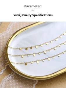 Detailed shot of triple layered gold titanium necklaces with teardrop and round pendants