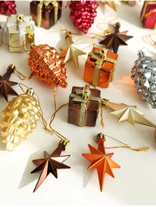 Flat lay of metallic gold and red Christmas ornaments including pinecones and gift boxes