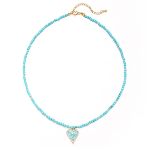 Macro shot of bohemian necklace featuring faceted blue beads and a heart pendant