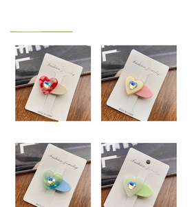 Detail of candy-colored acetate heart hair clips with inlaid crystals on jewelry cards