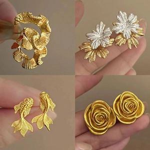 Three-piece set of vintage twisted metal hoop earrings with floral and goldfish designs