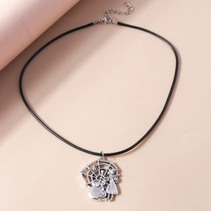 Close-up of witch, cauldron, and spider web charms on silver pendant necklace