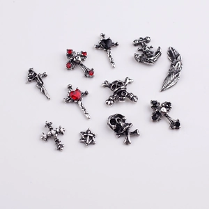 Macro shot of 12 vintage silver Halloween nail art charms including skulls and crosses