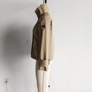 Detail of khaki cropped trench coat showing epaulettes and side double-breasted buttons